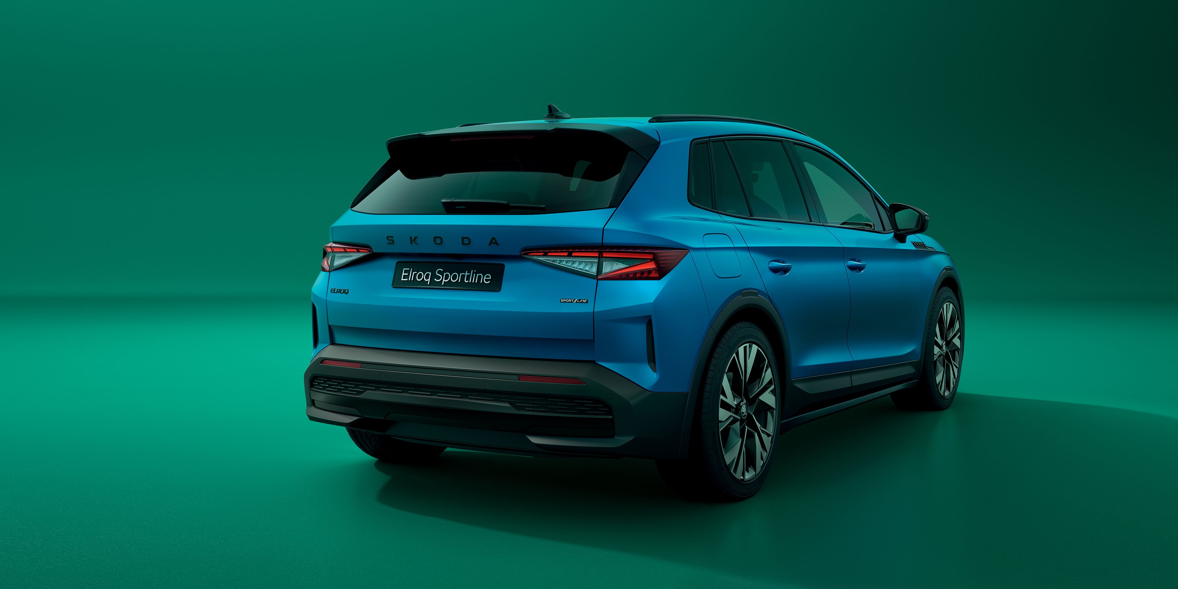 Škoda Elroq Sportline in blau auf grünem Hintergrund, sicht von hinten