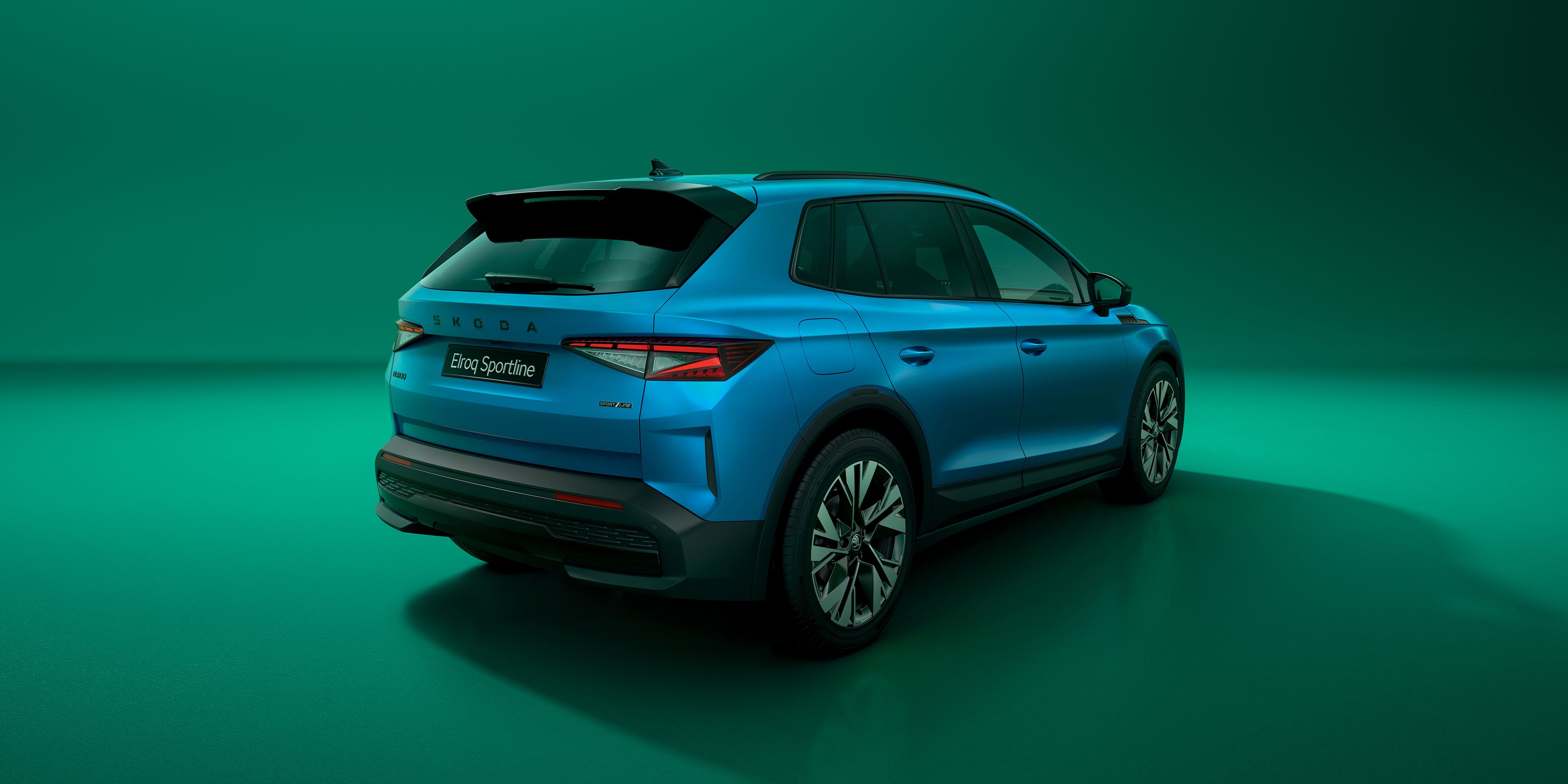 Škoda Elroq Sportline in blau auf grünem Hintergrund, sicht von hinten